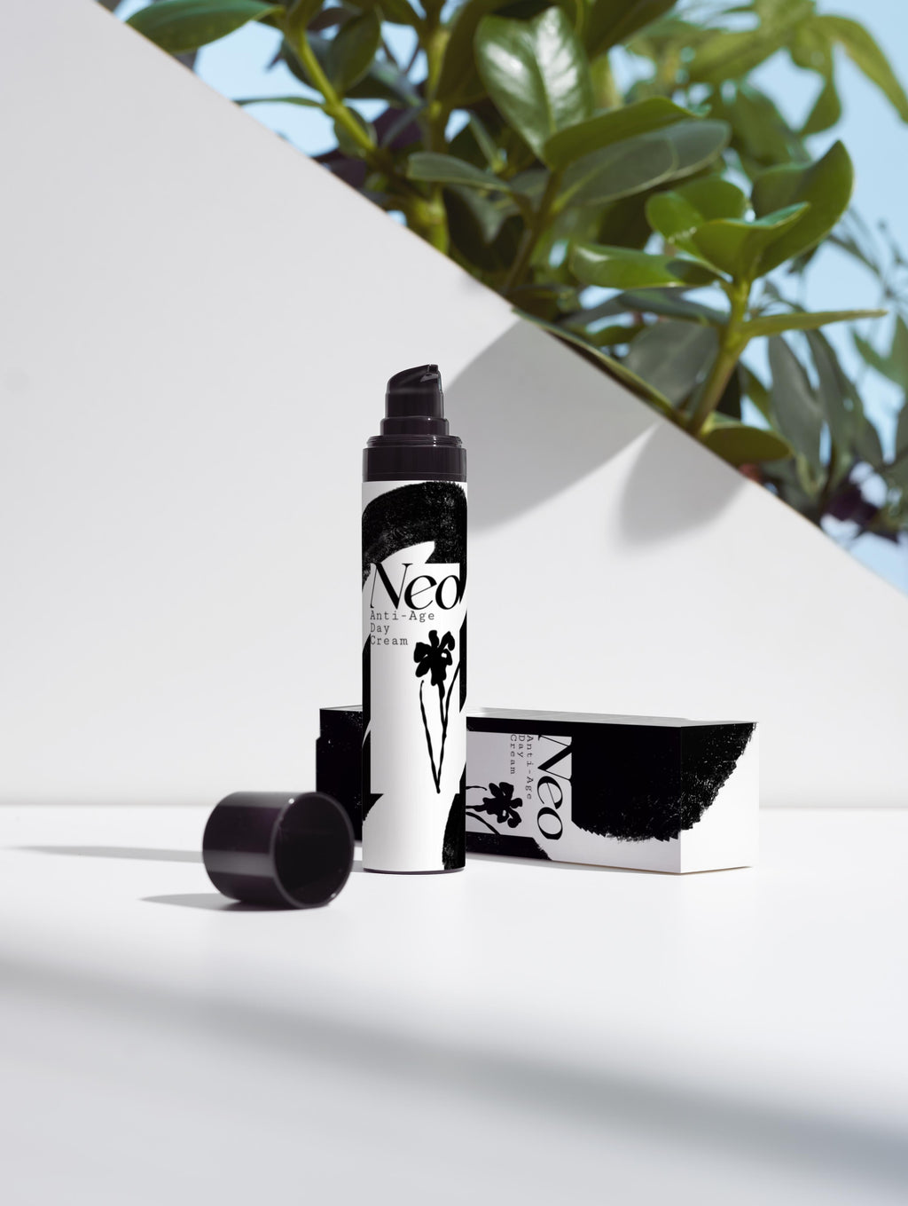 Black and white cosmetic product with 'Neo' branding on a white surface with greenery in the background
