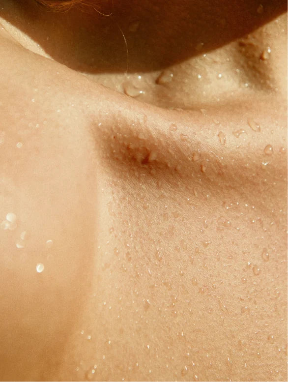 Close-up of a person's shoulder with visible skin texture and pores.