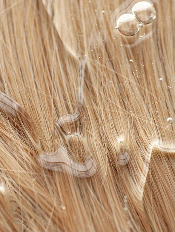 Close-up of blonde hair extensions with a focus on texture and color.