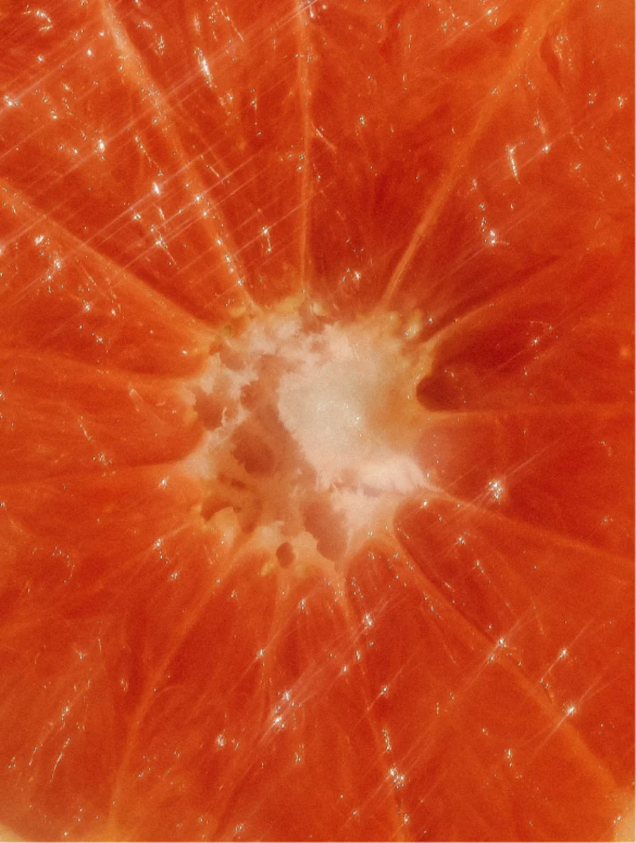 Close-up of a sliced grapefruit showing juicy interior and skin texture.